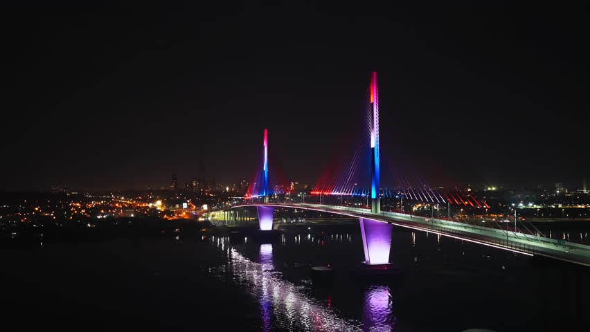 An illuminated view of the Heroes del Chaco Bridge in Asuncion shining over the Paraguay River at night