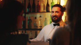 Two women sitting at bar counter, drinking cocktails and browsing mobile phone - Powered by Shutterstock - Get 15% off with code: PIKWIZARD15