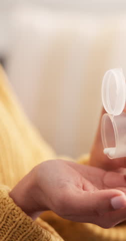 Pills, glass of water or hands of woman in home, prescription medicine or supplement for wellness. Antibiotics, virus cure or sick person with capsule container, drink or vitamin for health benefits