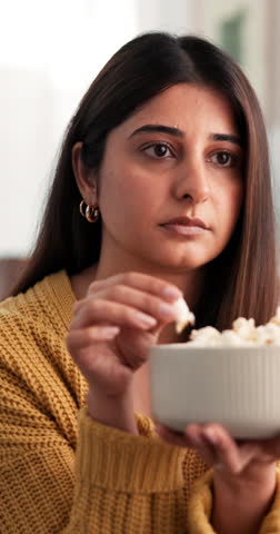 Popcorn, watching tv and relax with woman on sofa for streaming service, thriller film or eating snack. Movie subscription, entertainment program and food with person in living room of home for media