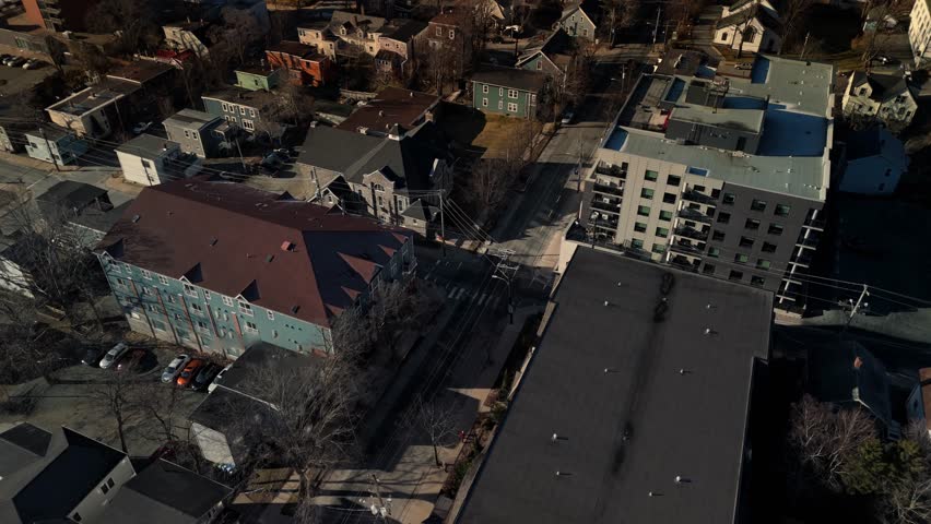 Cinematic aerial view Panoramic View Over Halifax, Nova Scotia, As The Sun Rises Over The Atlantic Ocean. Yachts Glide Through The Water Beside Coastal Skyscrapers And A Tranquil Cityscape.