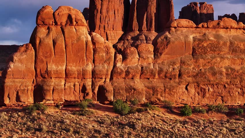 Aerial view of the sunlit, rugged sandstone formations in Arches National Park, standing majestically against the desert landscape, Moab, Grand County, United States.