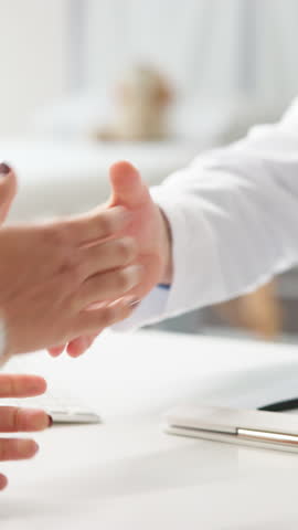Handshake, patient and doctor in hospital, consultation or feedback for test results. Closeup, shaking hands or people in clinic, medical service or healthcare with agreement for treatment plan