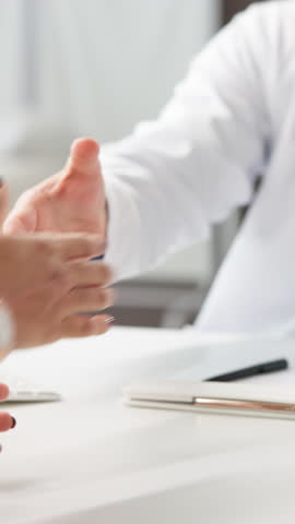 Handshake, patient and doctor in clinic, consultation or agreement for treatment plan. Closeup, shaking hands or professional with medical service, people or healthcare with feedback for test results