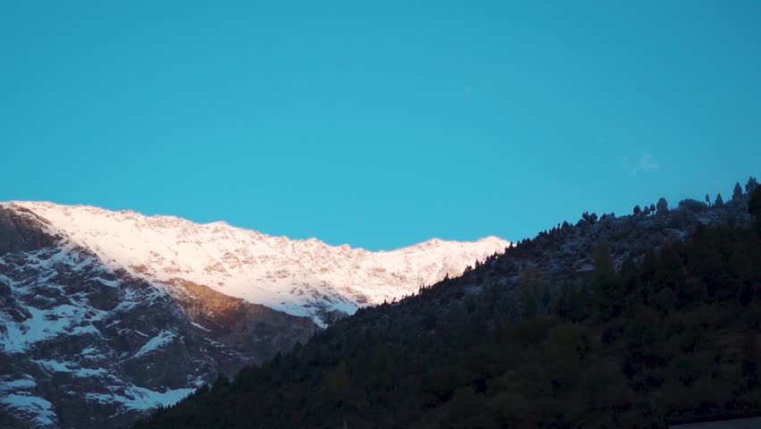 Early morning sunlight on top of the snowy Himalayan mountain peak after snowfall as seen from Keylong in Lahaul and Spiti district, Himachal Pradesh, India. Scenic view of sunrise in Himalayas.