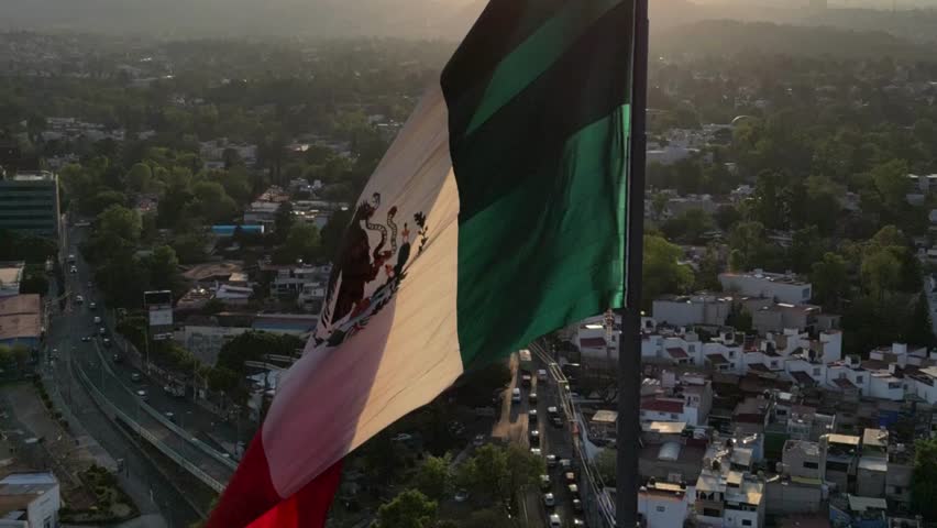 A breathtaking view of Mexico City (CDMX) featuring the Mexican flag waving proudly above the urban skyline, symbolizing national pride, heritage, and the vibrant spirit of the capital.