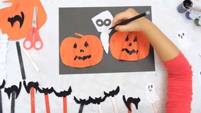 Child making pumpkins for the holiday of halloween. Funny crafts from paper. Halloween decor. Handicraft. The concept for Halloween. DIY. Children's art project, a craft for children. - Powered by Shutterstock - Get 15% off with code: PIKWIZARD15