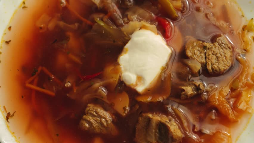 Borscht with sour cream. Delicious borscht soup with cabbage, potatoes, carrots, and beets. Just made in the kitchen at home. High quality 4k footage