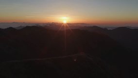 Sunstar shines over distant clouds and mountain range at dawn - Powered by Shutterstock - Get 15% off with code: PIKWIZARD15