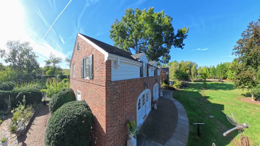 Experience the serene outdoors of Shenandoah Gardens in Winchester, Virginia. Enjoy views of the garden, museum, and surrounding landscape on a sunny day.