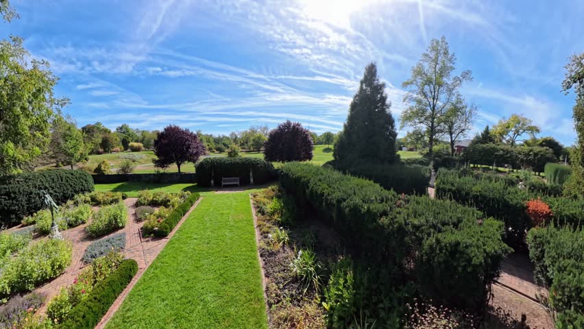 Experience the serene outdoor views of Shenandoah Gardens in Winchester, Virginia. Enjoy the beauty of nature and historical architecture on a sunny day.