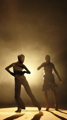 Graceful Teen Dance Duo Performing Under Dramatic Lighting