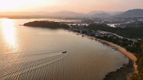 Warm golden sunset illuminating Phuket shoreline, wooden boat drifting across tranquil waters, reflecting peaceful tropical evening landscape, Thailand - Powered by Shutterstock - Get 15% off with code: PIKWIZARD15