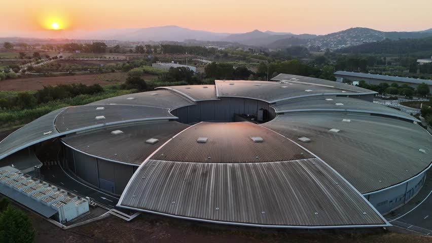 Drone footage of ALBA Synchrotron (ALBA II) particle accelerator building, Spain — aerial pull-back shot
