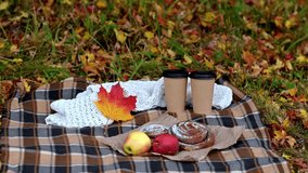 Cozy autumn picnic with coffee cups, apples and pastries on blanket while yellow leaves fall gently - Powered by Shutterstock - Get 15% off with code: PIKWIZARD15