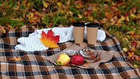 Cozy autumn picnic with coffee cups, apples and pastries on blanket while yellow leaves fall gently - Powered by Shutterstock - Get 15% off with code: PIKWIZARD15