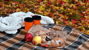 Cozy autumn picnic with coffee cups, apples and pastries on blanket while yellow leaves fall gently - Powered by Shutterstock - Get 15% off with code: PIKWIZARD15