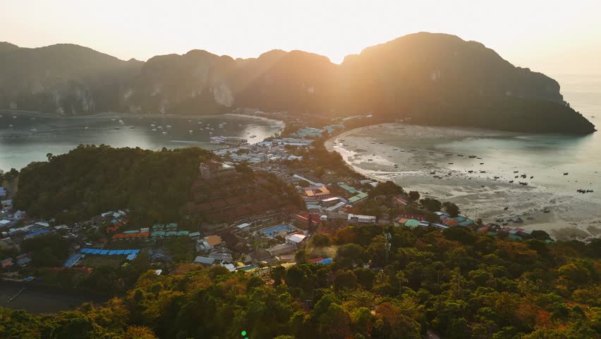 Warm golden sunlight illuminating scenic coastline of phi phi island in tranquil tropical Thailand landscape