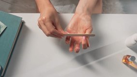 Woman filing nails during a home manicure session, focusing on self-care and beauty maintenance. - Powered by Shutterstock - Get 15% off with code: PIKWIZARD15