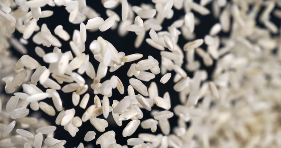 Slow Motion Explosion of White Rice Grains Falling and Flying in Air at 1000 fps. Macro Food Shot of Organic Rice in Dynamic Motion, Minimal Background, Healthy Nutrition and Natural Texture Concept