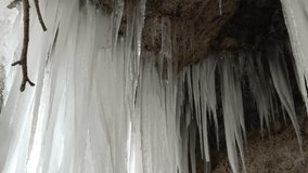 A frozen waterfall on a mountain river. The Bigar waterfall below Stara Planina is bound by ice. details of the icy stalactites around which the camera orbits. Unfrozen falling water flows between the - Powered by Shutterstock - Get 15% off with code: PIKWIZARD15