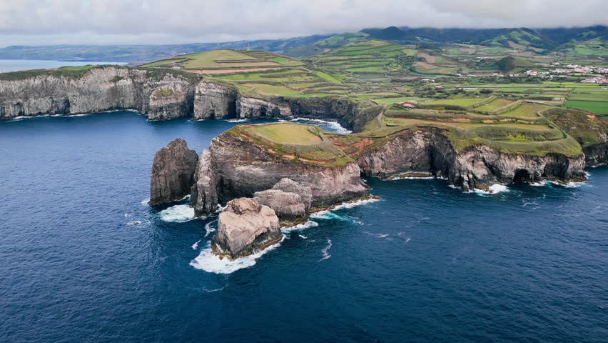Dark blue Atlantic water meeting basalt cliffs on Sao Miguel Island, Azores, aerial view. Rocky shoreline suitable