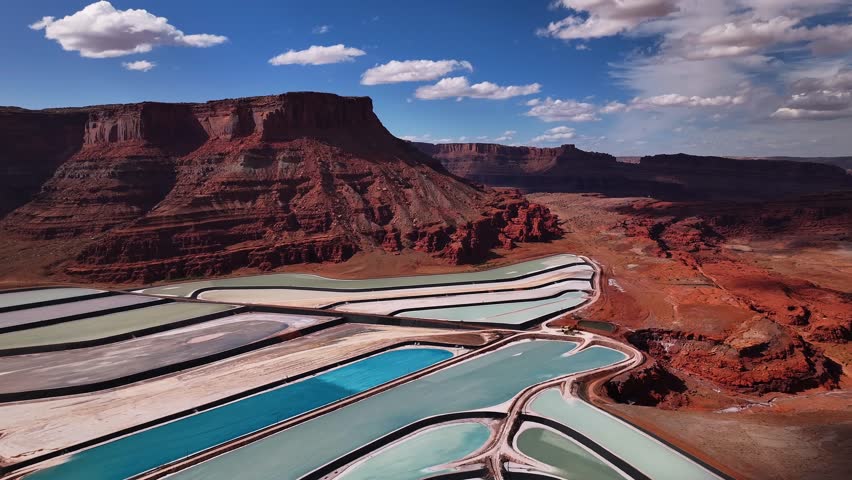 Aerial view of the contrasting colors of the potash ponds against the red mesas in the arid landscape, Potash Road, Moab, Utah, United States.