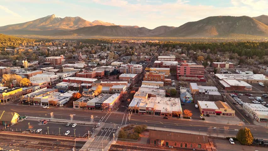 Flagstaff, United States - 10 November 2024: Aerial view of downtown Flagstaff, Arizona, with the San Francisco peaks in the background at sunrise.