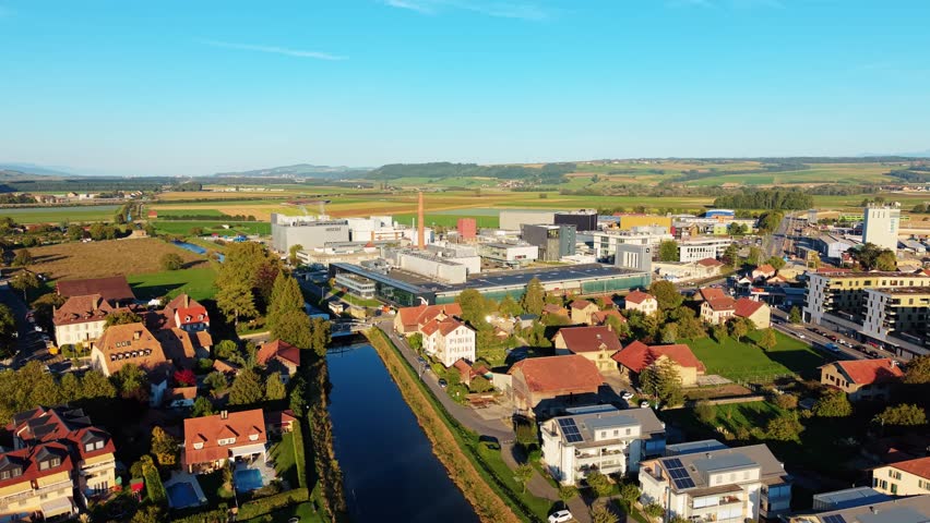 Orbe, Switzerland - 19 September 2025: Aerial view of the Nestle Product Technology Center with its modern buildings amidst the town and verdant fields.