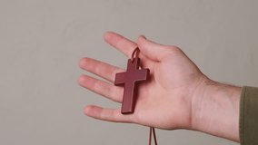 A Hand Gripping a Wooden Cross Accompanied by a Set of Rosary Beads for Reflection and Prayer - Powered by Shutterstock - Get 15% off with code: PIKWIZARD15