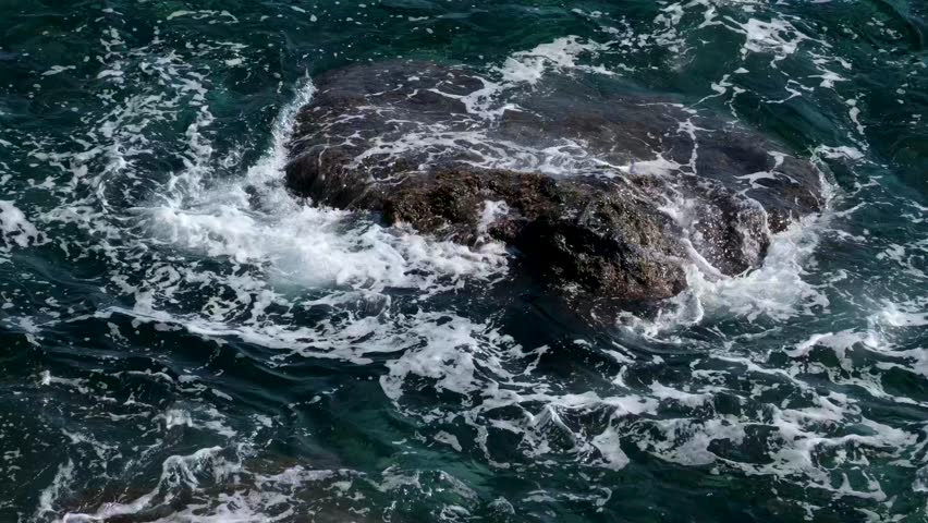 Rock ocean waves dynamic seascape shows waves crashing against rugged rocks, creating splashes and foam everywhere.