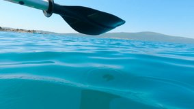 Kayaker paddling in turquoise water. Turquoise water splashes gently as a kayaker propels forward, the paddle rhythmically dipping beneath the surface, creating patterns of droplets and ripples - Powered by Shutterstock - Get 15% off with code: PIKWIZARD15