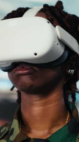 Vertical video Close up of soldier providing combat support, looking at reconnaissance feeds using VR goggles. Intelligence agency professional uses battlefield communication network and virtual