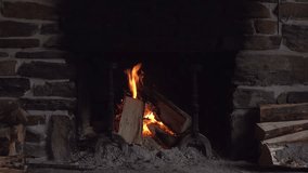 A warm fireplace scene featuring burning logs and glowing embers set in a rustic stone hearth. Perfect for conveying home warmth, cozy ambiance, and rustic decor in living spaces. - Powered by Shutterstock - Get 15% off with code: PIKWIZARD15