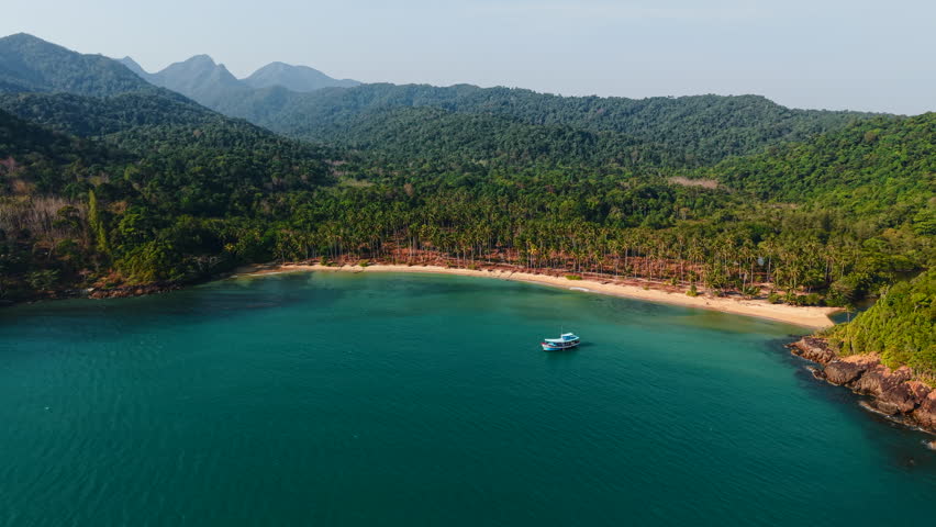 Lush vegetation meets crystal clear turquoise waters at wai chaek beach, a secluded haven on koh chang island