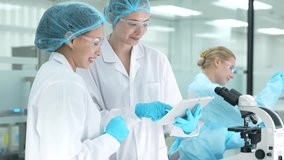 A diverse team of female scientists collaborates in a modern research lab. Two colleagues review experimental data on a digital tablet while another works at a microscope. - Powered by Shutterstock - Get 15% off with code: PIKWIZARD15