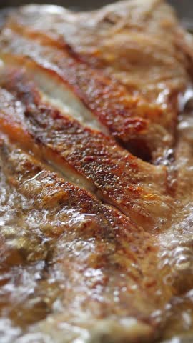 Close-up of crispy white snapper fish texture frying in bubbling oil.