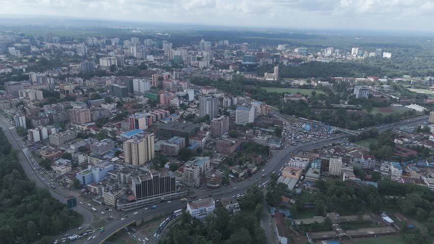 A beautiful aerial drone footage of the cityscape of Nairobi, Kenya, showcasing urban office spaces, modern residential areas, the Nairobi Expressway, and Waiyaki Way. Captured during the day.