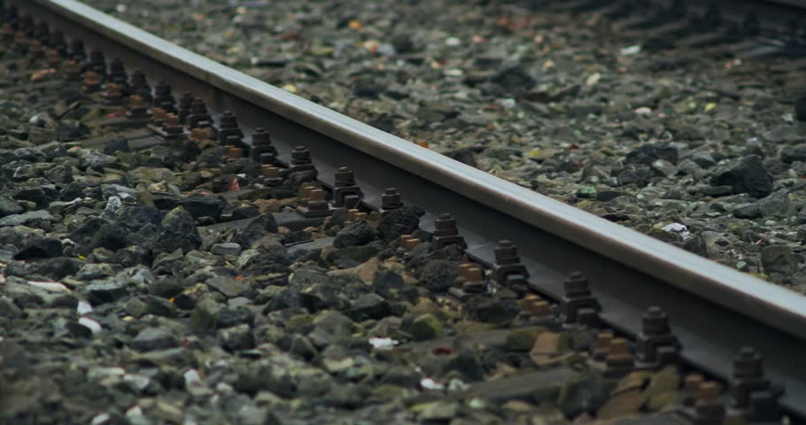 Stone Ballast Covers Sleepers Between Steel Rail Train Tracks Pan Shot