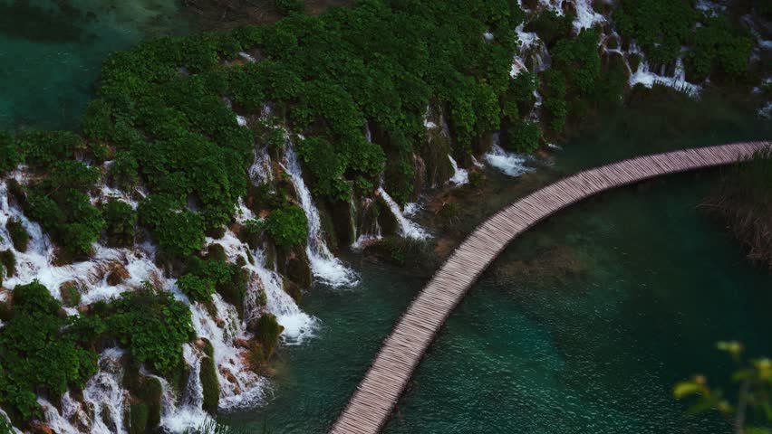Plitvice Lakes, Croatia. Blue pool, turquoise water. Waterfalls flowing gently at wooden path.