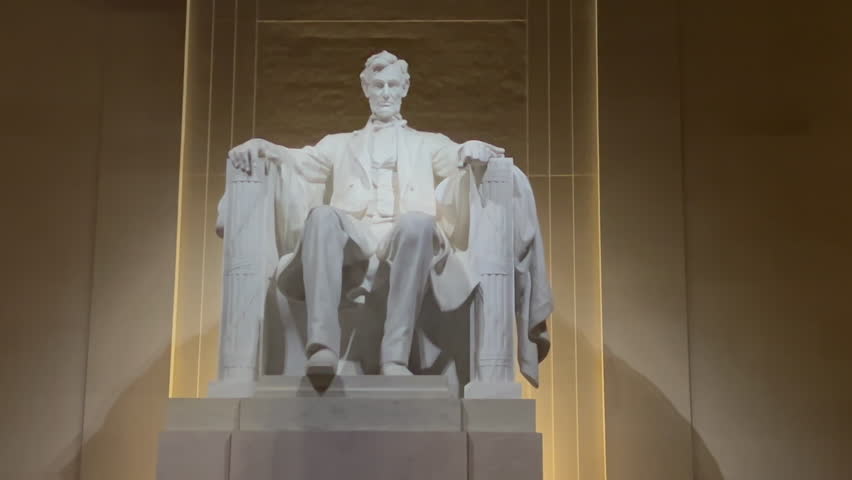 Abraham Lincoln Memorial Statue in Washington D.C. with night lighting. The stately marble statue honoring the U.S. Civil War President is viewed straight on with steady zoom in.