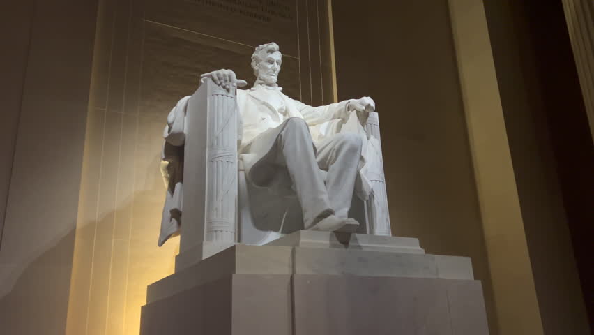 Abraham Lincoln Memorial Statue in Washington D.C. with night lighting. The marble statue of the U.S. Civil War President is viewed at an angle with a with steady zoom in.