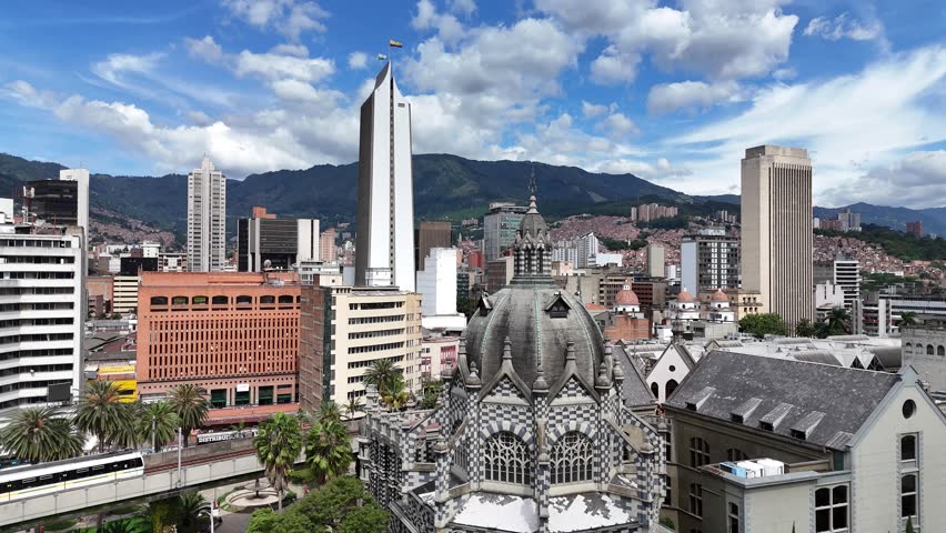 An architectural landmark in Medellín, Colombia — the Palacio de la Cultura Rafael Uribe Uribe stands majestically in Plaza Botero, surrounded by lush greenery and modern city buildings.