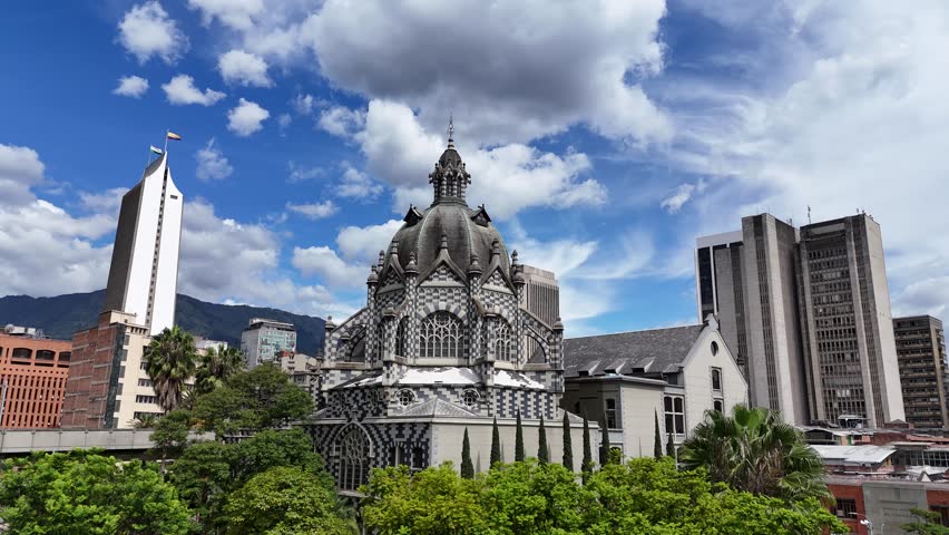 An architectural landmark in Medellín, Colombia — the Palacio de la Cultura Rafael Uribe Uribe stands majestically in Plaza Botero, surrounded by lush greenery and modern city buildings.