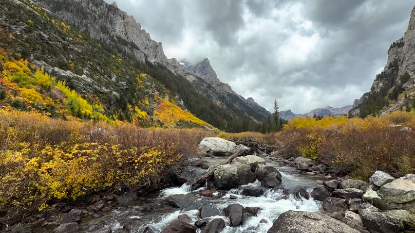 Time-lapse of South Fork Cascade Canyon in Grand Teton National Park, with clouds drifting around rugged peaks—scenic, wilderness landscape captured in a stable, wide composition - Powered by Shutterstock - Get 15% off with code: PIKWIZARD15