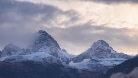 Telephoto timelapse of Grand and Middle Teton at sunrise from Teton Valley as dramatic clouds race past snowcapped peaks—moody, layered mountain landscape - Powered by Shutterstock - Get 15% off with code: PIKWIZARD15