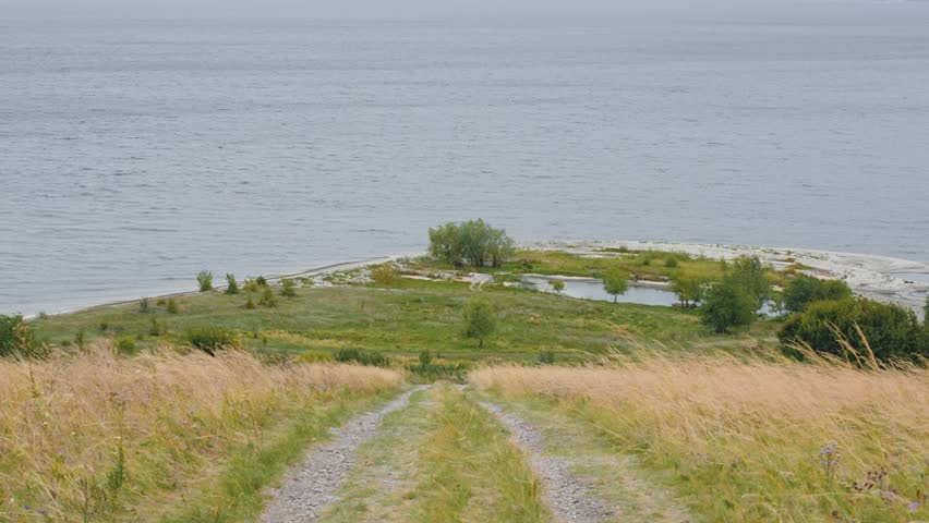 Village path in the field from the mountain to the river
