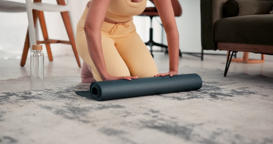 Hands, woman and roll yoga mat on floor for home workout, start exercise routine and preparation. Yogi, morning and person with pilates equipment in apartment for getting ready, wellness and fitness