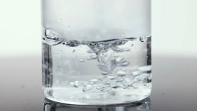 Hot water poured into clear glass beaker, creating bubbles in bright, high-key studio lighting - Powered by Shutterstock - Get 15% off with code: PIKWIZARD15