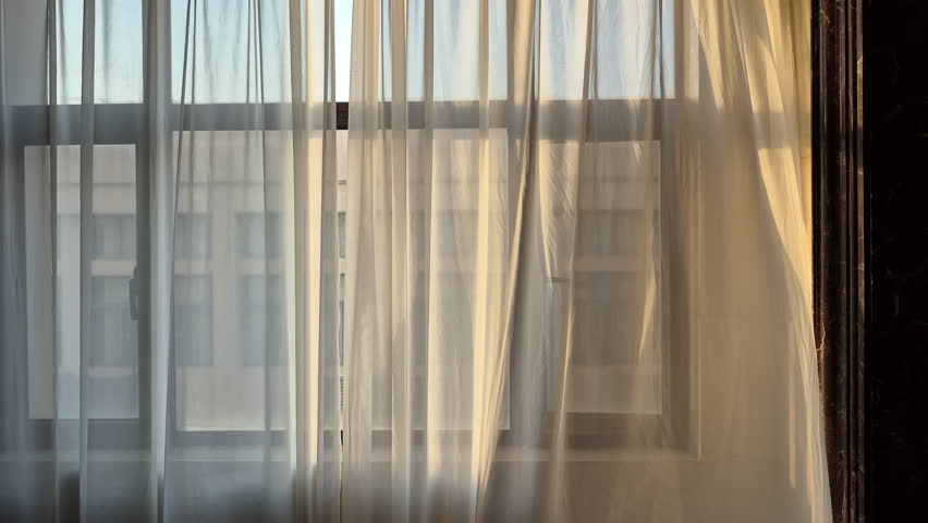 Cool wind breeze through apartment transparent white curtain morning sunlight